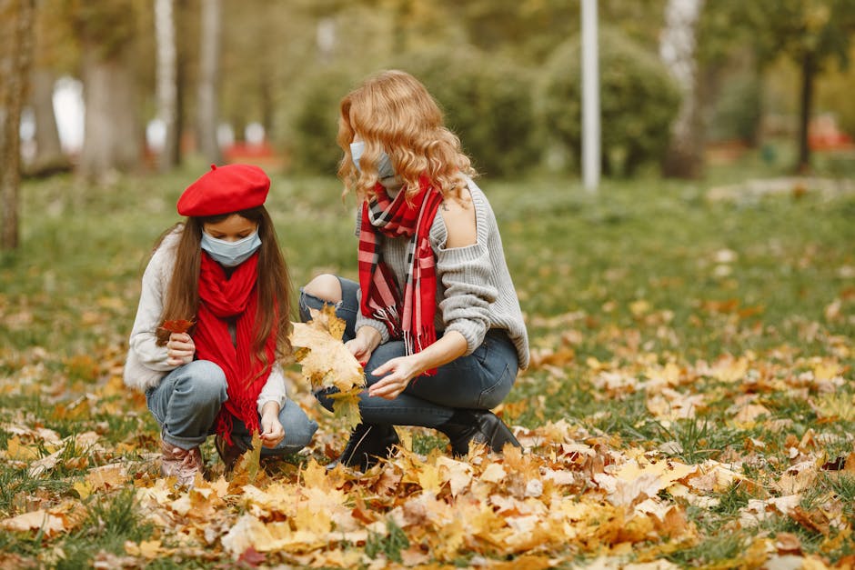 Family enjoying autumn outdoors in masks